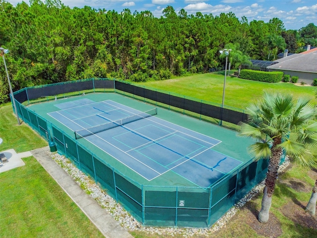 view of tennis court featuring a lawn