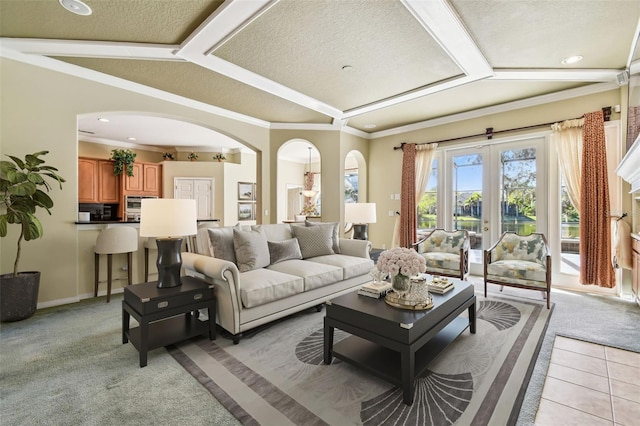 living room featuring lofted ceiling, ornamental molding, a textured ceiling, light carpet, and french doors