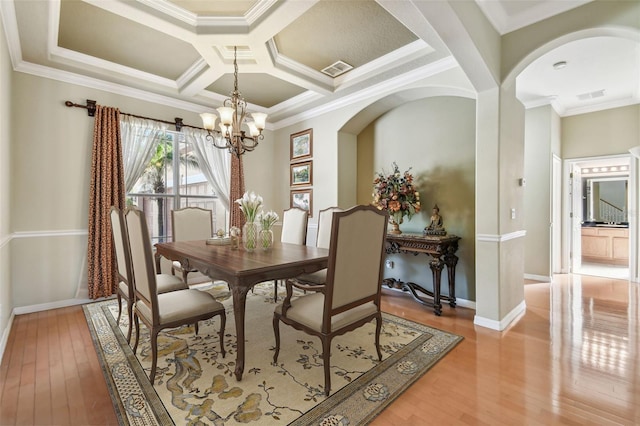 dining space featuring crown molding, coffered ceiling, an inviting chandelier, and light hardwood / wood-style floors