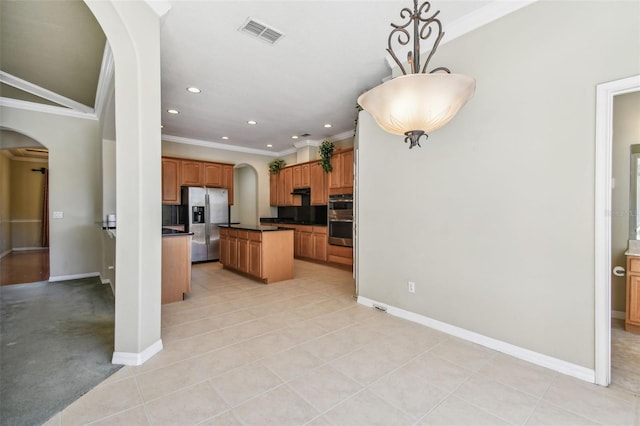 kitchen with pendant lighting, appliances with stainless steel finishes, a center island, ornamental molding, and light tile patterned flooring