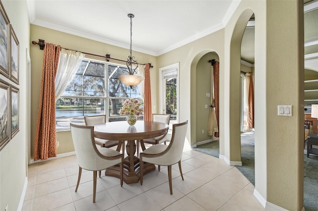 tiled dining room featuring ornamental molding and plenty of natural light