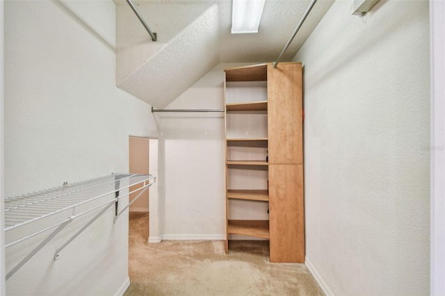 spacious closet featuring light carpet and lofted ceiling