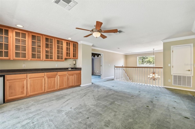 kitchen with pendant lighting, sink, crown molding, and light carpet