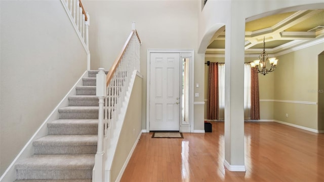 2024 Capri Ln, Mount Dora, FL 32757 - foyer entrance featuring arched walkways, wood finished floors, ornamental molding, a chandelier, and stairs