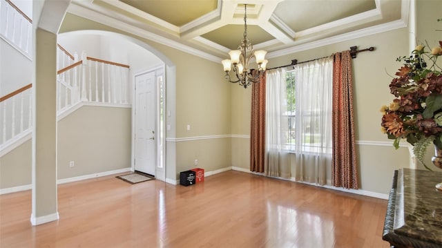 2024 Capri Ln, Mount Dora, FL 32757 - unfurnished dining area featuring a chandelier, wood finished floors, arched walkways, crown molding, and stairway