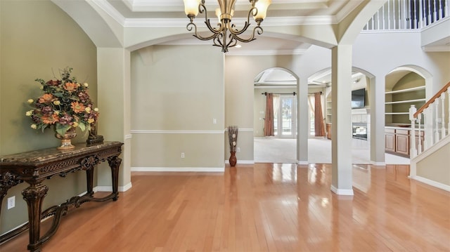 2024 Capri Ln, Mount Dora, FL 32757 - entryway featuring a chandelier, light wood finished floors, arched walkways, crown molding, and stairs