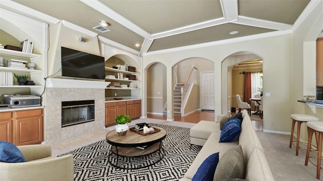 2024 Capri Ln, Mount Dora, FL 32757 - living area with arched walkways, ornamental molding, built in shelves, a tiled fireplace, and vaulted ceiling