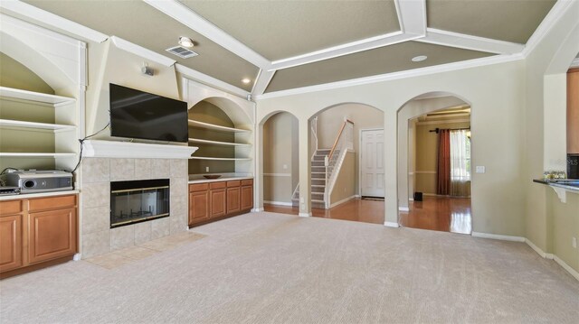 2024 Capri Ln, Mount Dora, FL 32757 - unfurnished living room with carpet flooring, crown molding, a tile fireplace, built in features, and stairs