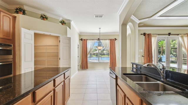 2024 Capri Ln, Mount Dora, FL 32757 - kitchen with appliances with stainless steel finishes, ornamental molding, light tile patterned floors, dark stone counters, and brown cabinetry