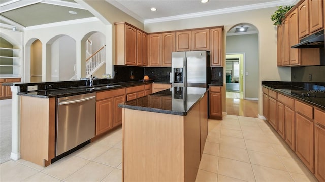 2024 Capri Ln, Mount Dora, FL 32757 - kitchen featuring stainless steel appliances, a kitchen island, crown molding, dark stone countertops, and arched walkways