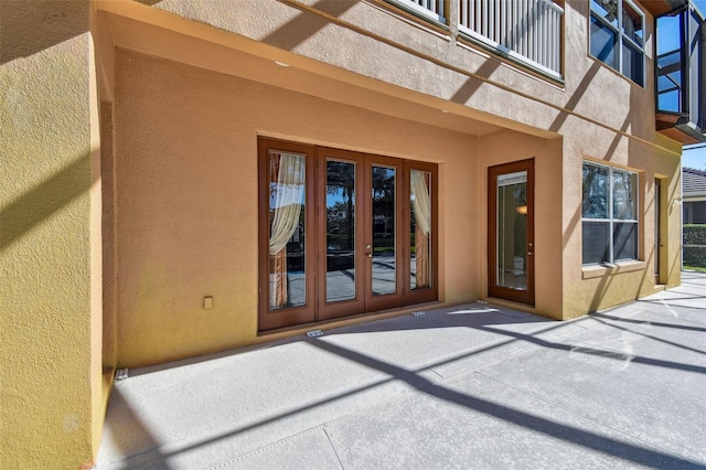 2024 Capri Ln, Mount Dora, FL 32757 - view of exterior entry with french doors, stucco siding, a balcony, and a patio area