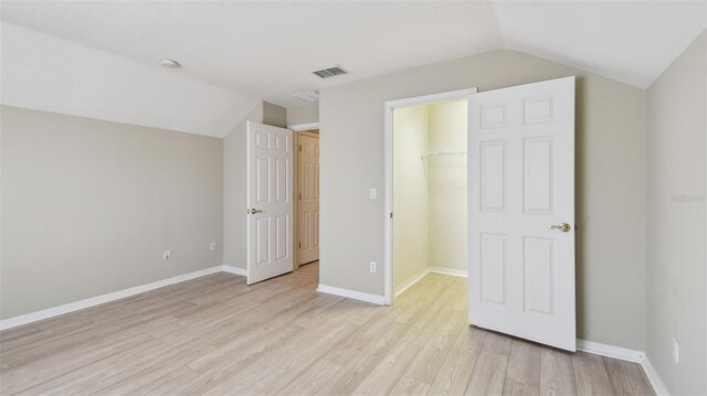 2024 Capri Ln, Mount Dora, FL 32757 - unfurnished bedroom with lofted ceiling, light wood-style flooring, a walk in closet, and a closet