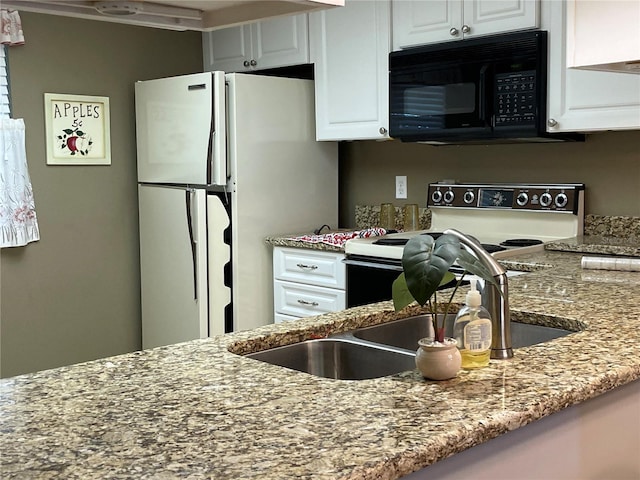 kitchen with light stone countertops, white appliances, white cabinetry, and sink