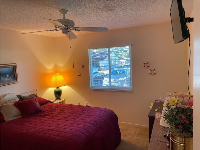 carpeted bedroom featuring ceiling fan and a textured ceiling