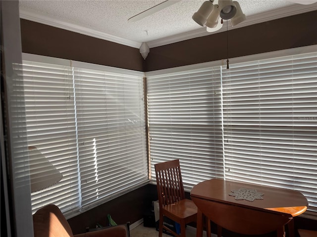 dining area featuring a textured ceiling, ceiling fan, and crown molding