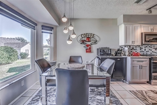 dining area with light tile patterned floors and a textured ceiling