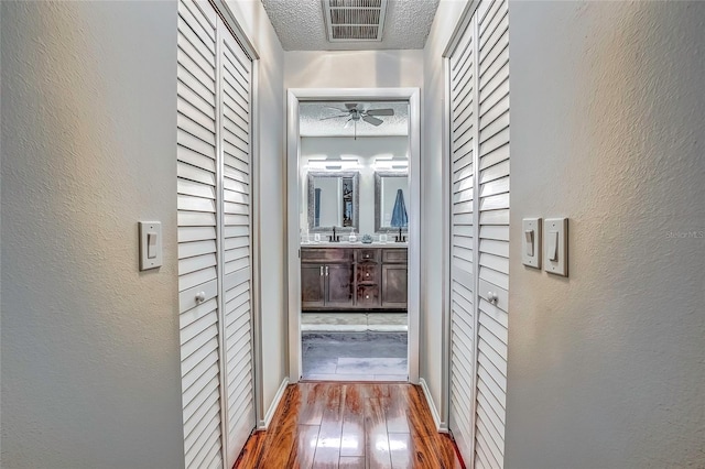 hallway featuring hardwood / wood-style floors and a textured ceiling