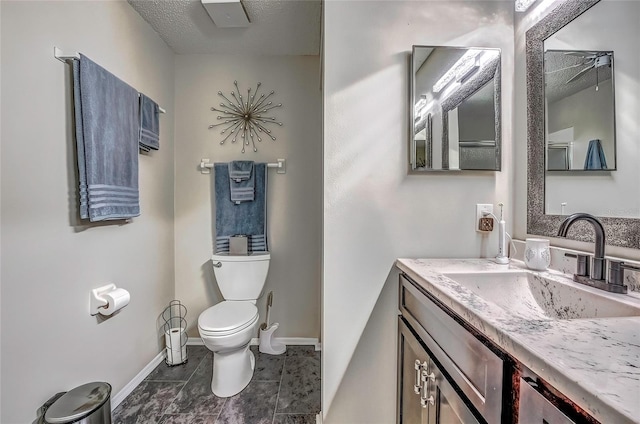 bathroom with vanity, a textured ceiling, and toilet