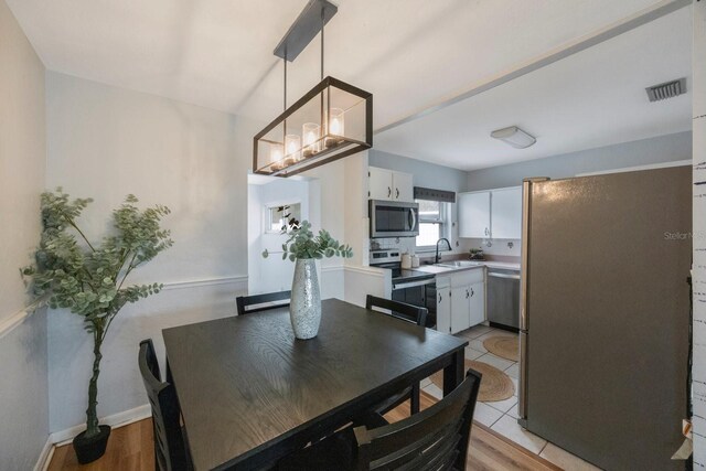 dining area featuring light wood-type flooring and sink