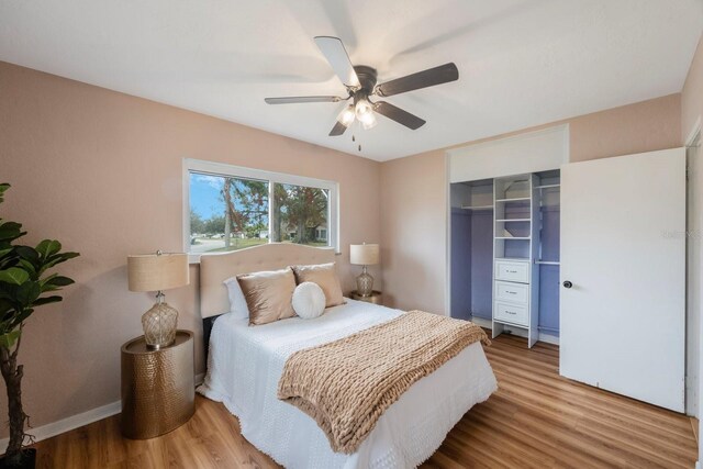 bedroom with a closet, hardwood / wood-style flooring, and ceiling fan