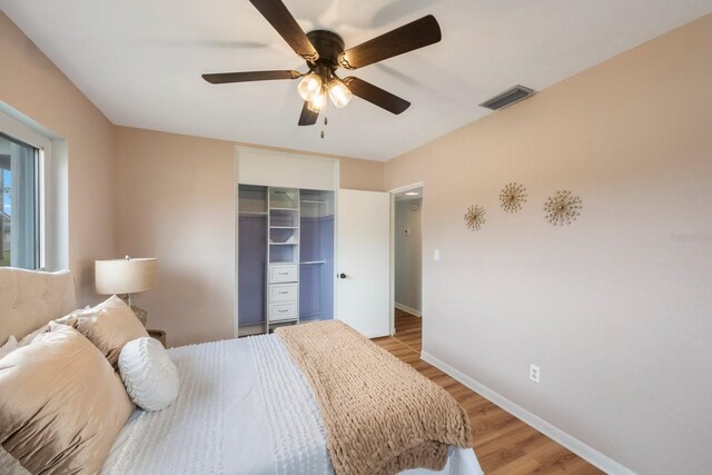 bedroom with ceiling fan, light hardwood / wood-style floors, and a closet