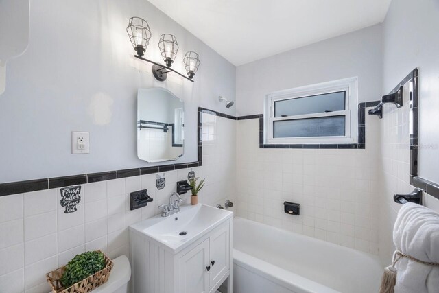 bathroom featuring vanity, tile walls, and toilet