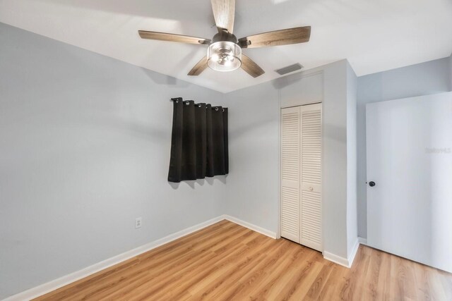 unfurnished bedroom with ceiling fan, light hardwood / wood-style flooring, and a closet