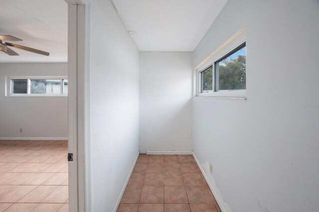 tiled spare room with ceiling fan