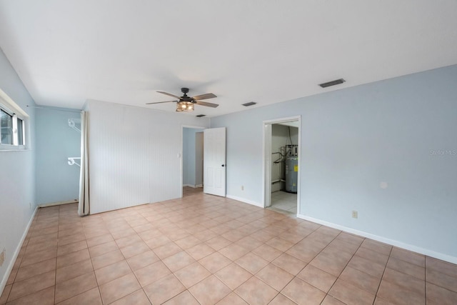 spare room with gas water heater and ceiling fan