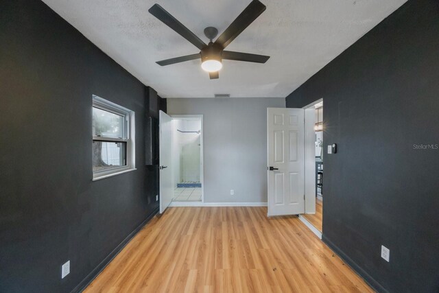 unfurnished bedroom with ceiling fan, a textured ceiling, and light wood-type flooring