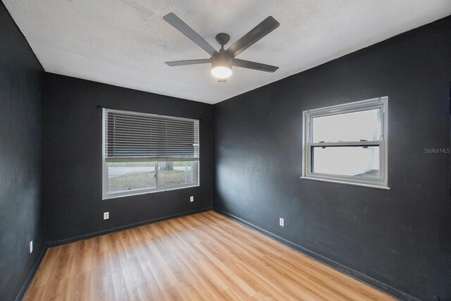 empty room featuring ceiling fan, light hardwood / wood-style floors, and a textured ceiling