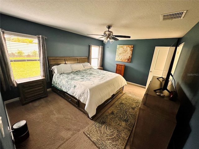 carpeted bedroom featuring a textured ceiling and ceiling fan