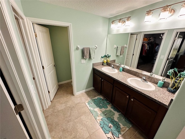 bathroom featuring tile patterned floors, vanity, and a textured ceiling