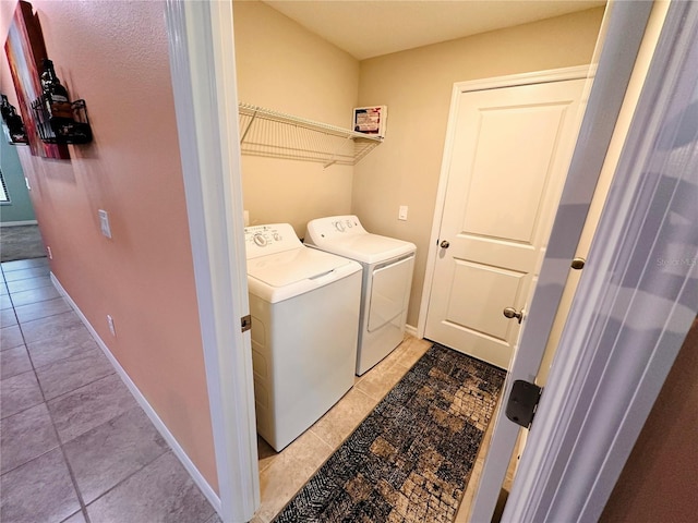 laundry room with light tile patterned flooring and washing machine and clothes dryer