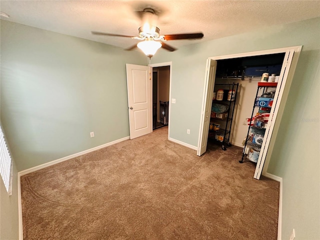 unfurnished bedroom with ceiling fan, carpet floors, and a textured ceiling