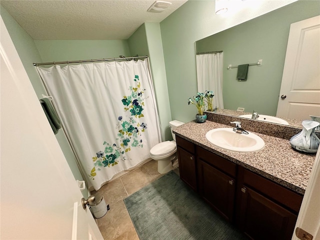 bathroom featuring vanity, tile patterned floors, a textured ceiling, and toilet