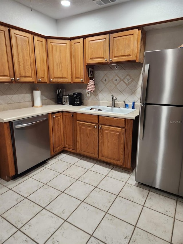 kitchen featuring light tile patterned flooring, backsplash, stainless steel appliances, and sink