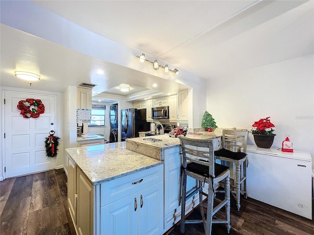 kitchen featuring light stone countertops, fridge, dark hardwood / wood-style flooring, kitchen peninsula, and black fridge with ice dispenser