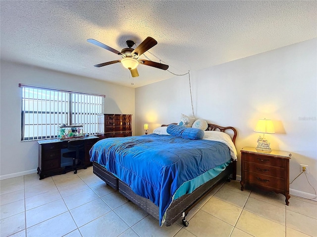 bedroom with ceiling fan, light tile patterned floors, and a textured ceiling