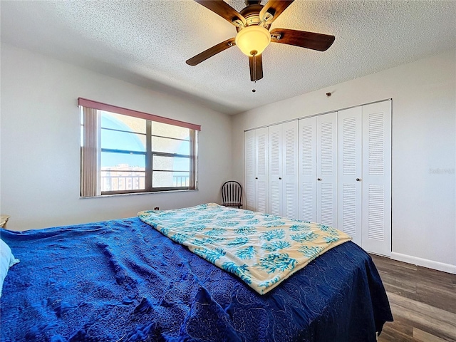 bedroom with a closet, ceiling fan, dark hardwood / wood-style flooring, and a textured ceiling