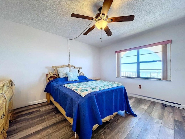 bedroom with ceiling fan, dark hardwood / wood-style flooring, and a textured ceiling