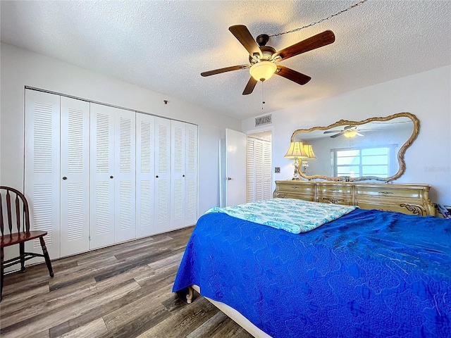 bedroom with ceiling fan, wood-type flooring, and a textured ceiling