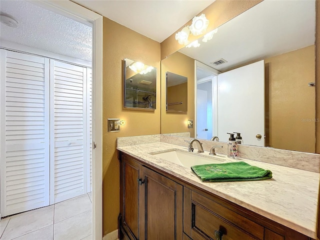 bathroom featuring a textured ceiling, vanity, and tile patterned floors