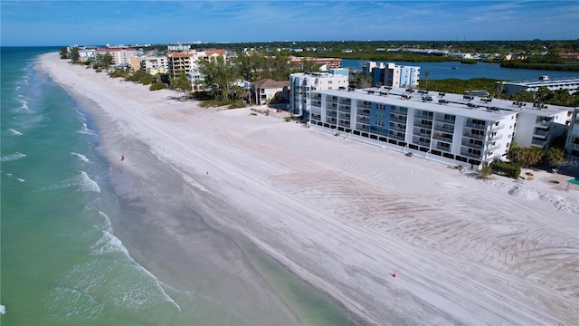 birds eye view of property with a water view and a beach view