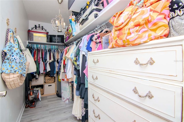 walk in closet with light hardwood / wood-style floors