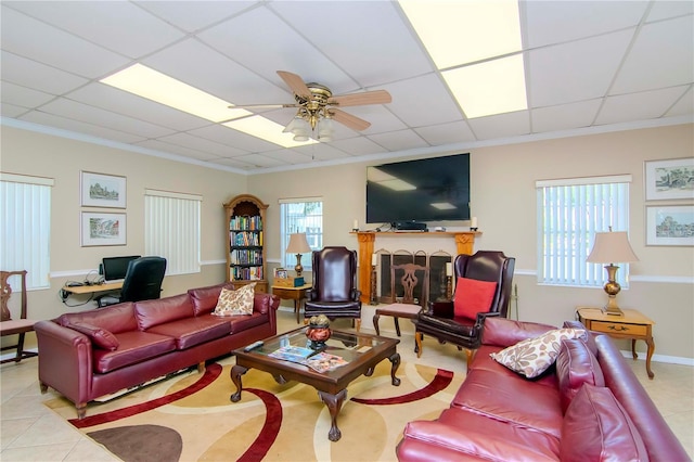 tiled living room featuring a paneled ceiling, ceiling fan, and ornamental molding