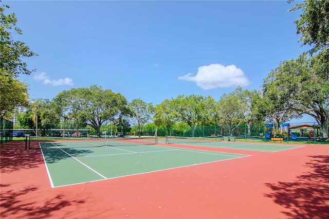 view of tennis court with community basketball court and fence