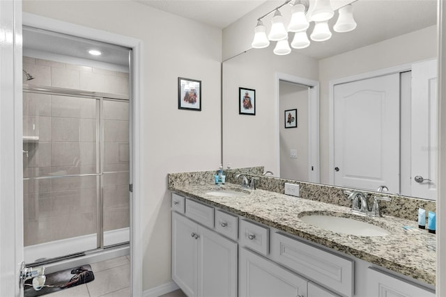 bathroom with tile patterned floors, a shower with door, and vanity