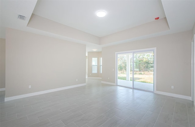 spare room with a tray ceiling