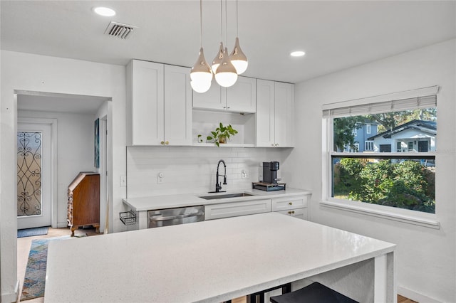 kitchen with dishwasher, light wood-type flooring, white cabinetry, and sink